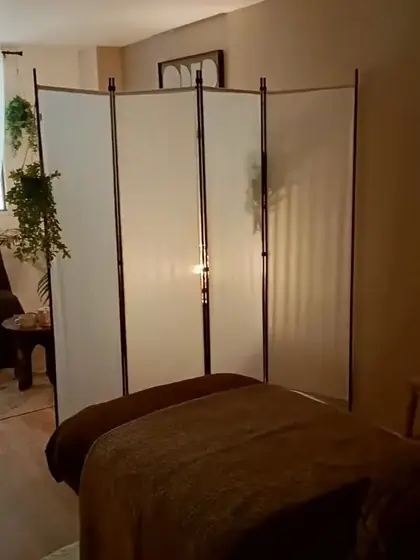 Table de soin devant le paravent blanc et les plantes